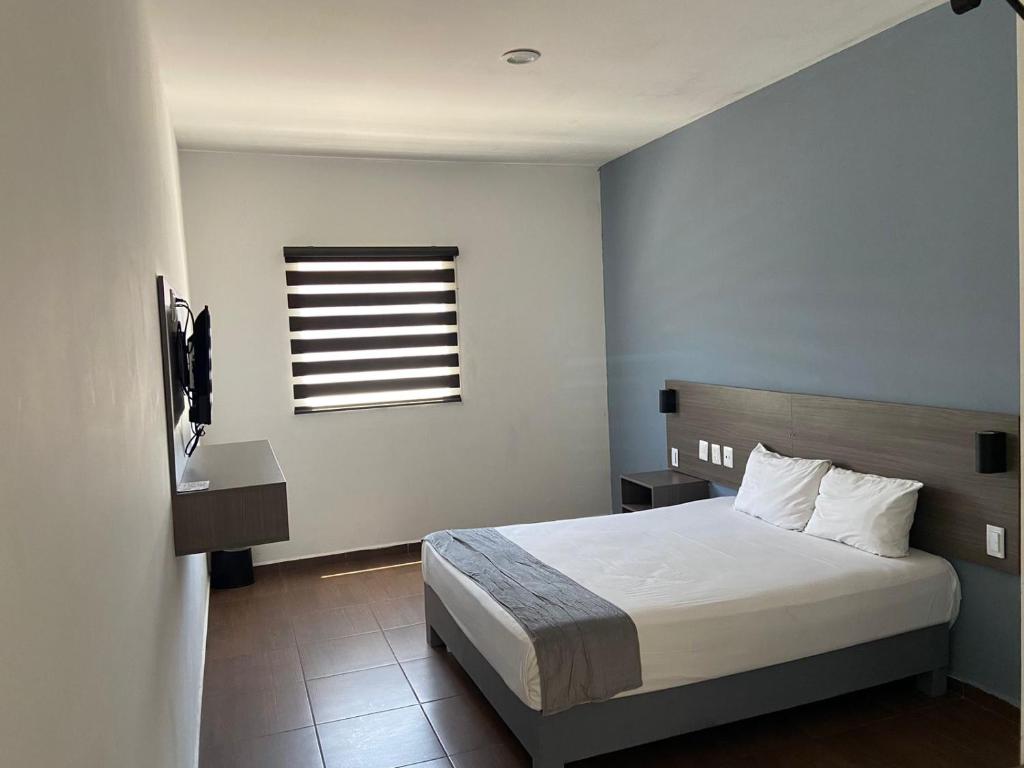 a bedroom with a white bed and a window at Al&oacute; Select Mazatlan in Mazatl&aacute;n