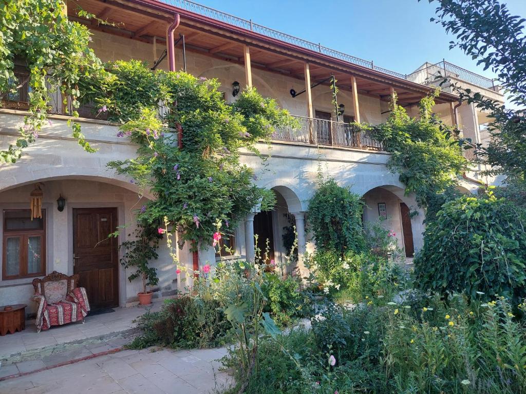 an old house with a garden in front of it at Kemal's Guest House in Goreme