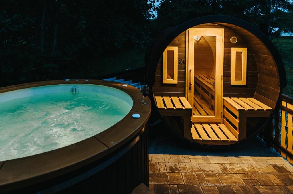 a large hot tub with a deck and a sauna at Forest Garden & House in Izvoare