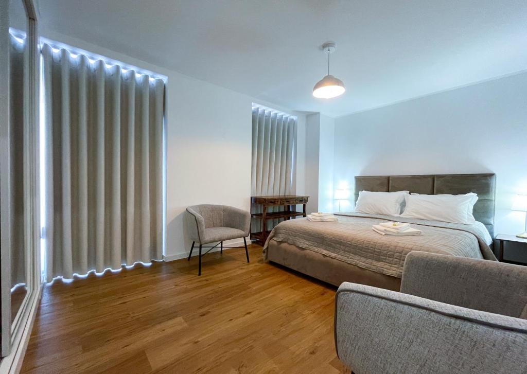 a bedroom with a bed and a chair and a window at Lisboa Intendente 3Bedroom Apartment with Balcony in Lisbon
