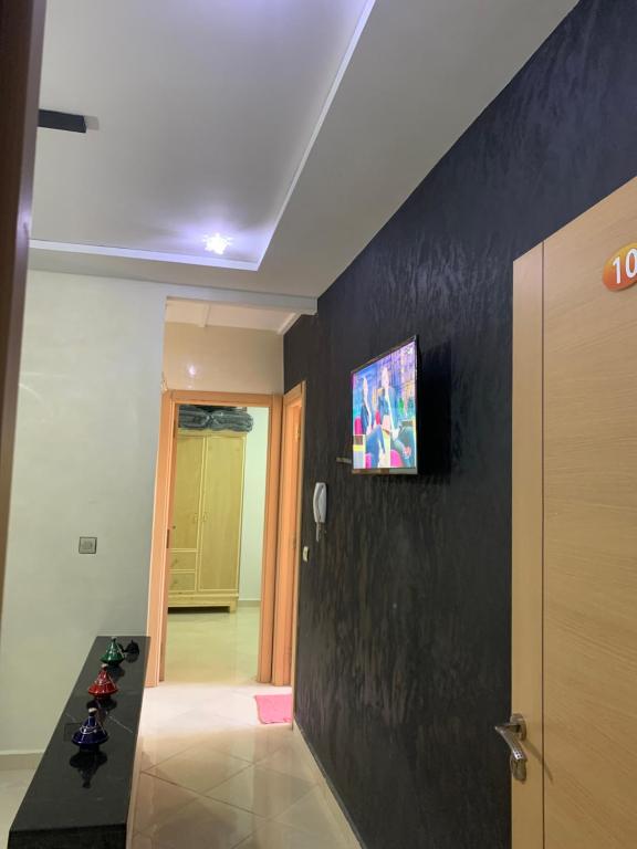 einen Flur mit einer schwarzen Wand und einem TV darauf in der Unterkunft Appartement cosy et pratique in Oujda