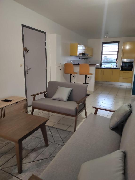 a living room with a couch and a table at La Coraline Standing in Kourou