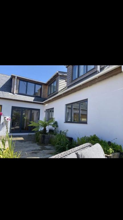 a large white house with windows on the side of it at Storm Cottage B&B in Hugh Town