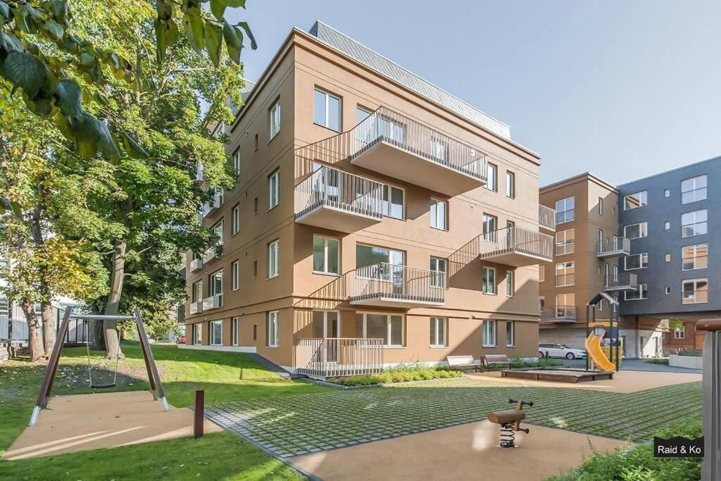 apartamentowiec z placem zabaw przed nim w obiekcie W Apartments Torupilli, terrace, green yard, parking w Tallinnie