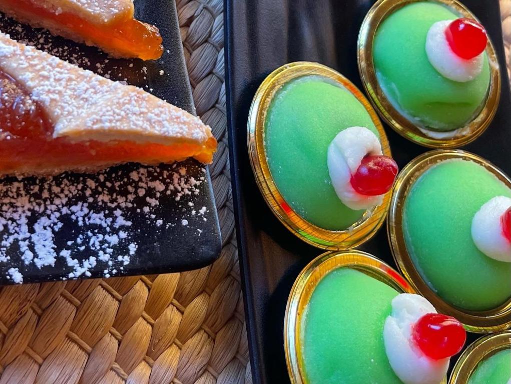 a table with a plate of desserts and a cake at B&B La Torre in Realmonte