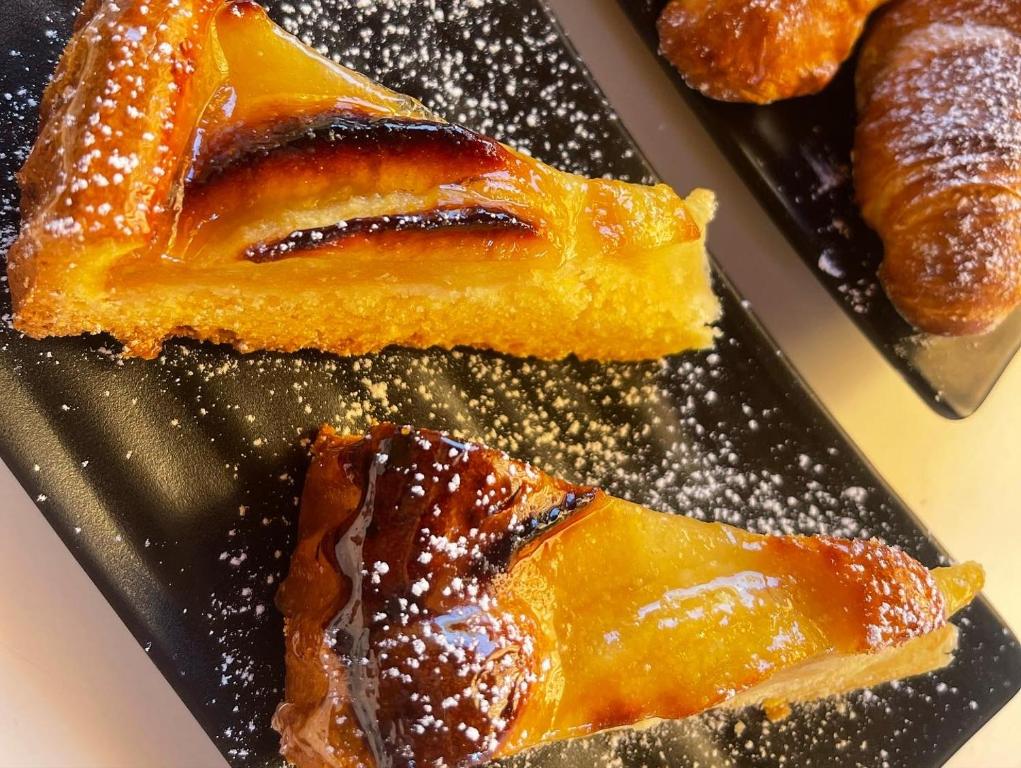a black plate with a piece of cake and pastries at B&B La Torre in Realmonte