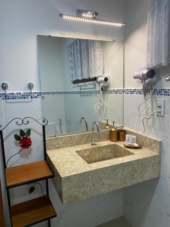 a bathroom with a sink and a mirror at Pousada Antígona in Paraty
