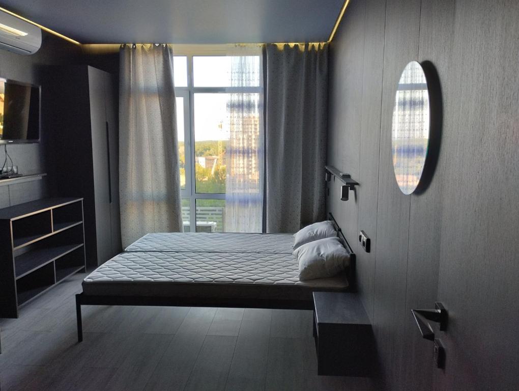 Un dormitorio con una cama y una ventana grande en Номер-студіо "Міні Феофанія" Заболотного 148, Кришталеві Джерела, лікарня, пораненим воїнам -10", en Kiev