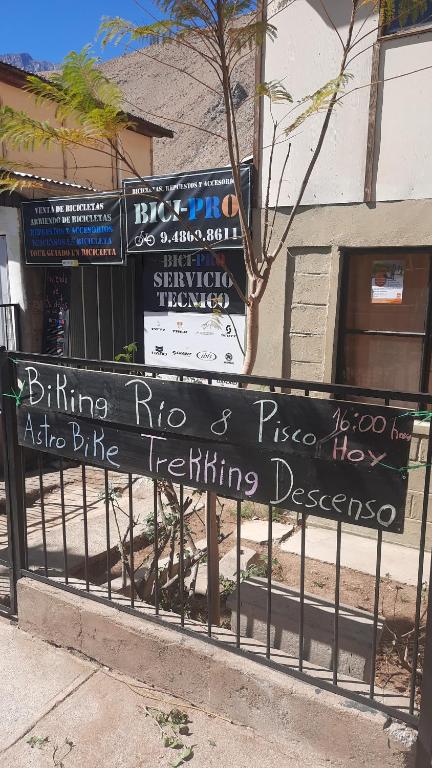 un cartello su una recinzione di fronte a un edificio di Casa Pueblo a Pisco Elqui