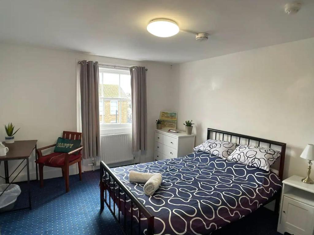 1 dormitorio con cama, escritorio y ventana en The Traders Inn, en Londres