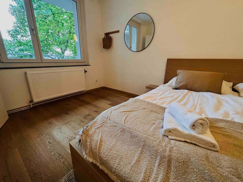 1 dormitorio con 1 cama con espejo en la pared en Urbaner Charme: Stilvolles Wohnen im Herzen Wiens en Viena