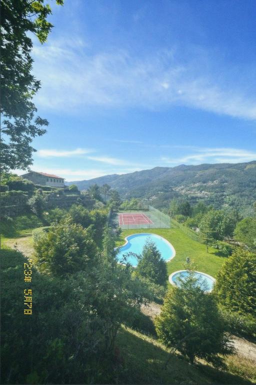 a view of two swimming pools in a green field at Casa Encosta da Caniçada in Vieira do Minho
