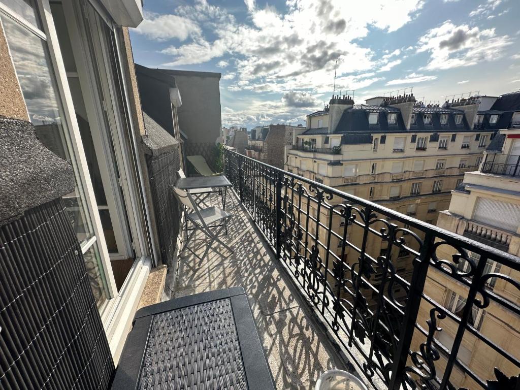 un balcon avec une table et des chaises sur un immeuble dans l'établissement TiParis, à Paris