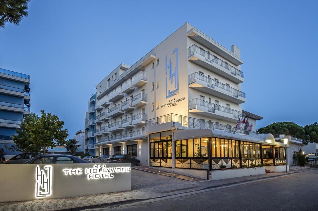 un gran edificio blanco con un cartel delante en Hotel Hollywood***S, en Lido di Jesolo