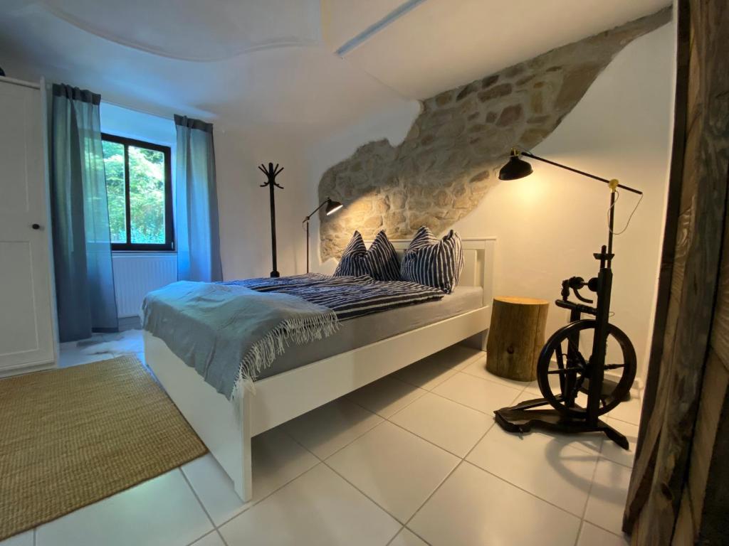 a bedroom with a bed with a stone wall at Mlýn Slavonice in Slavonice