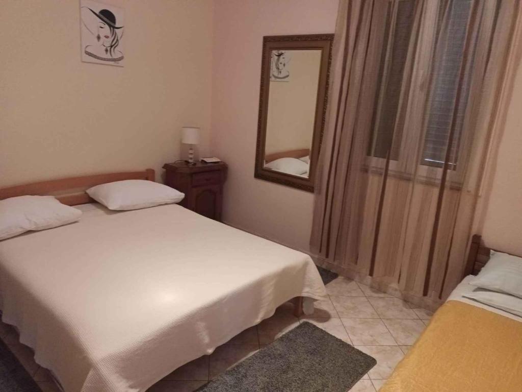 małą sypialnię z łóżkiem i lustrem w obiekcie Studio in Privlaka/Zadar Riviera 7840 w mieście Privlaka