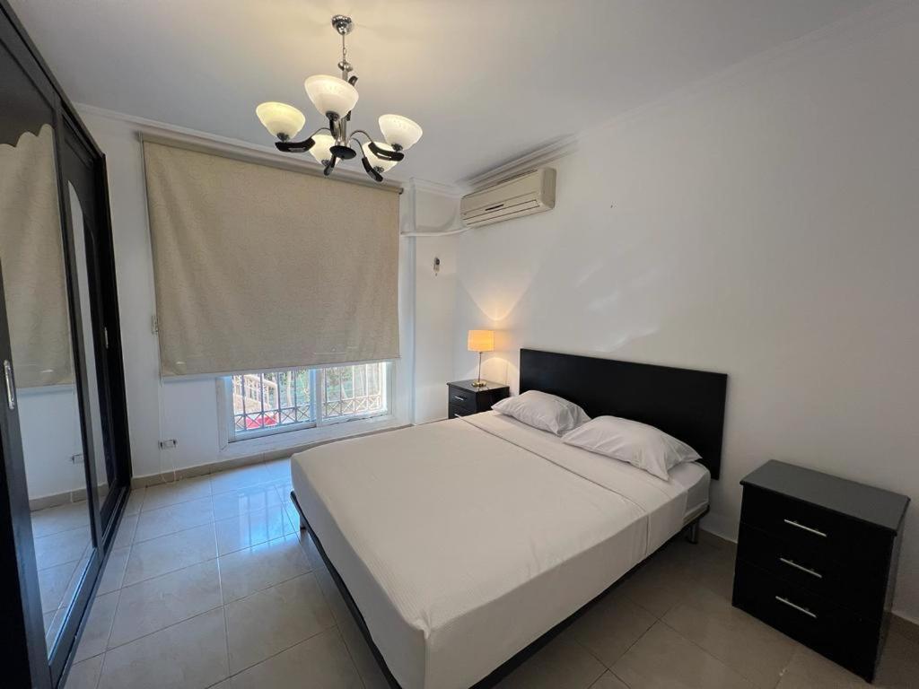 a bedroom with a white bed and a window at Madinaty, Elite new apartment with garden in Madinaty