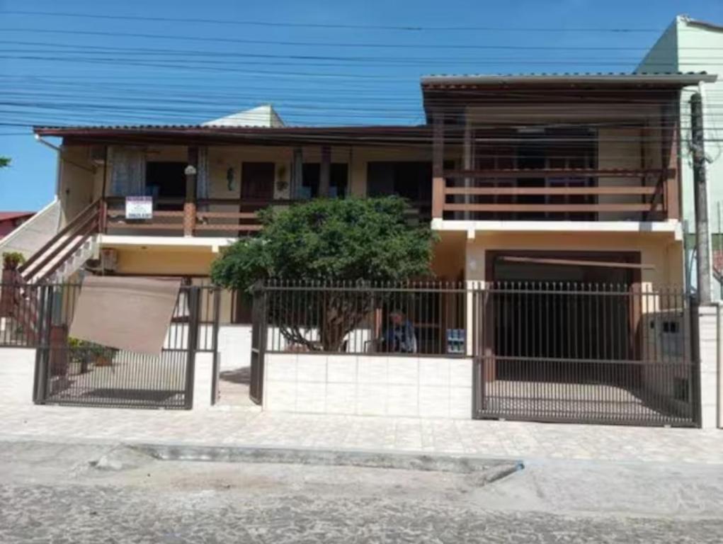 a house with a gate in front of it at Alugo quarto, próximo à praia in Torres