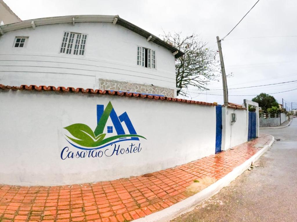 un bâtiment avec un panneau sur son côté dans l'établissement Casarão hostel, à Arraial do Cabo