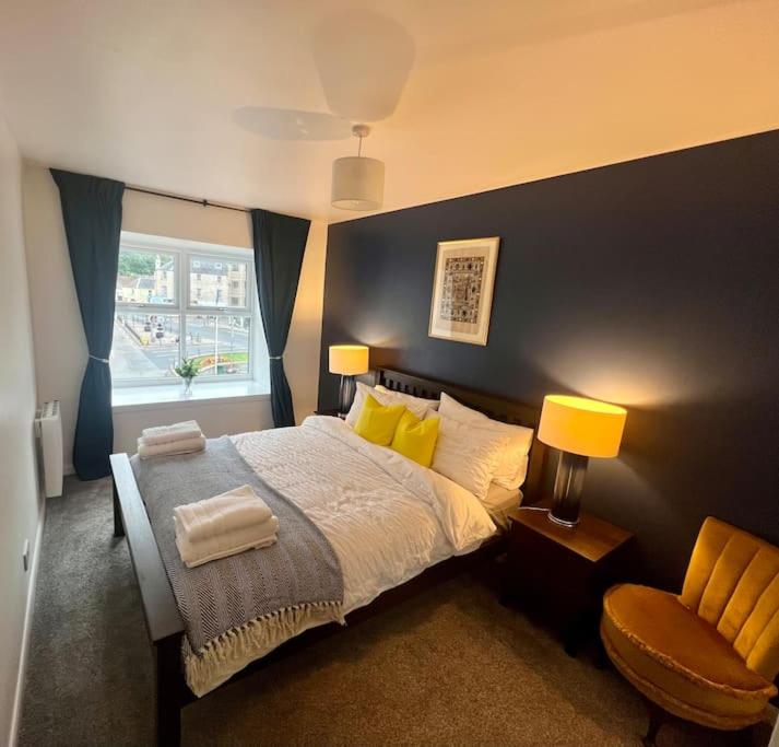 een slaapkamer met een groot bed en een stoel bij 16 Macgregor court, Oban in Oban