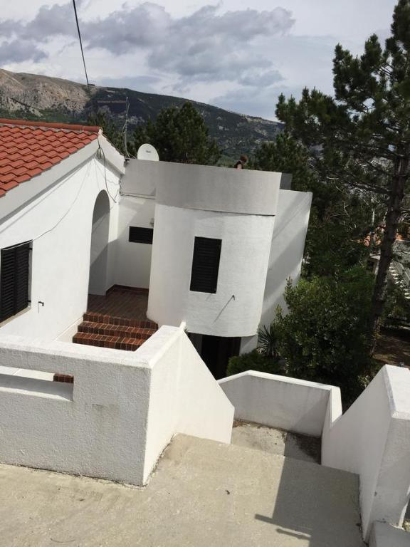 a white house with a staircase in front of it at Apartments Peace&Love in Baška