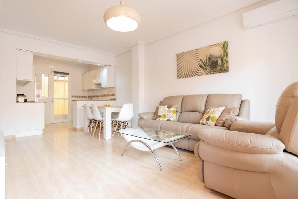 ein Wohnzimmer mit Sofa und Tisch in der Unterkunft Villa Mariposa in Orihuela