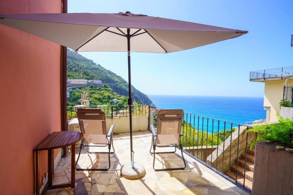 a patio with a table and chairs and an umbrella at Ca' du Cila in Riomaggiore