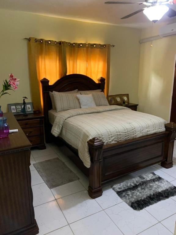 a bedroom with a large bed with a wooden headboard at Mini Cozy Lodging in Culloden