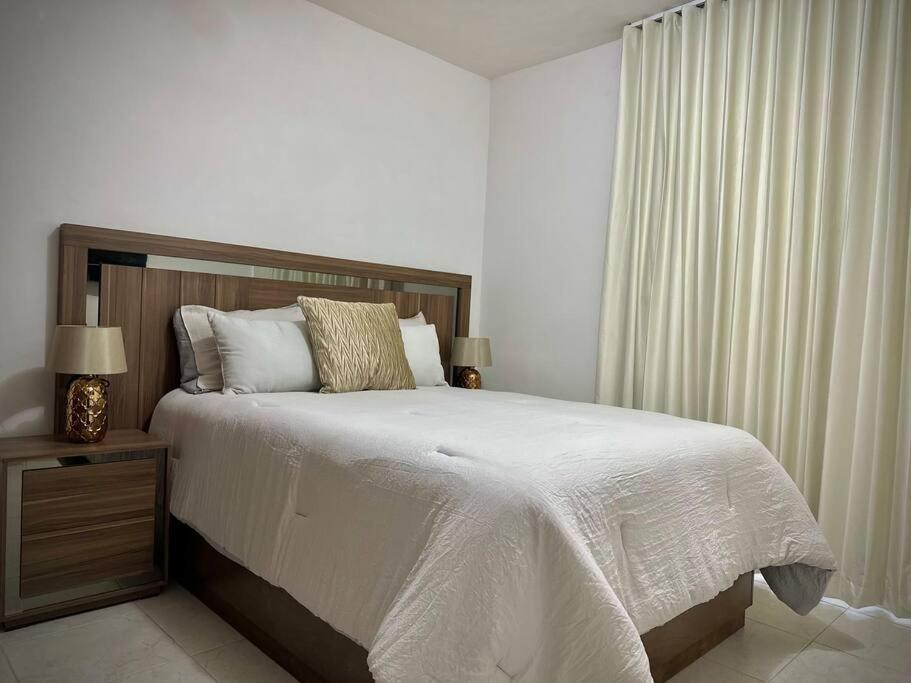 Un dormitorio con una cama grande y una ventana en Departamento Longoria 4A, en Matamoros