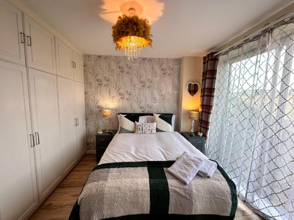 een slaapkamer met een groot bed en een kroonluchter bij Chelsea 2-Bedroom and Living Room Apartments in Londen