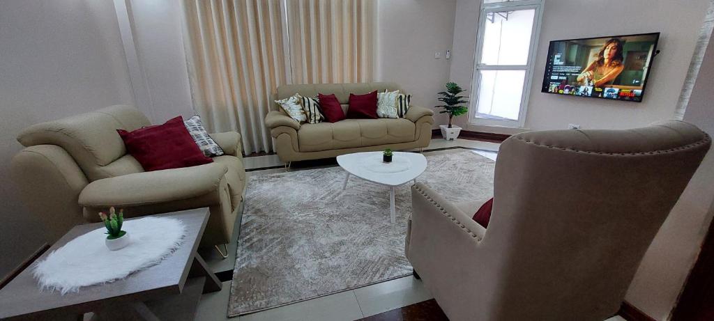 un salon avec deux canapés et une table dans l'établissement Sami BnB - Apt 05 Makongo after Mlimani City, à Dar es Salaam