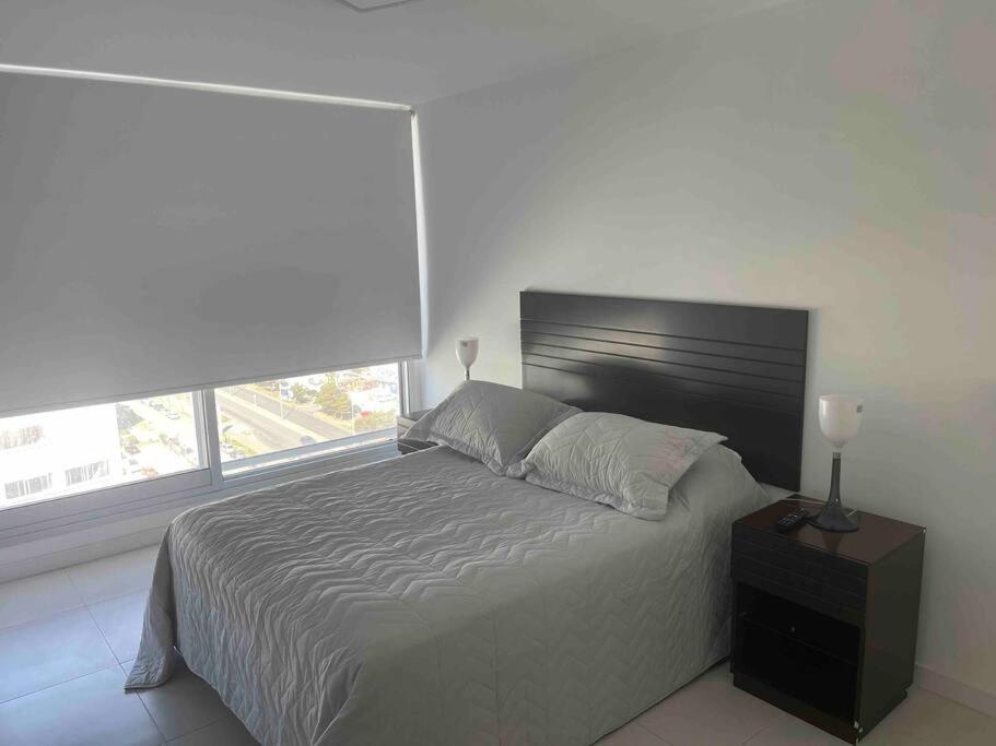 Un dormitorio con una cama grande y una ventana en Torre Bellagio piso 14 Hermoso depto 3 personas en Punta del Este