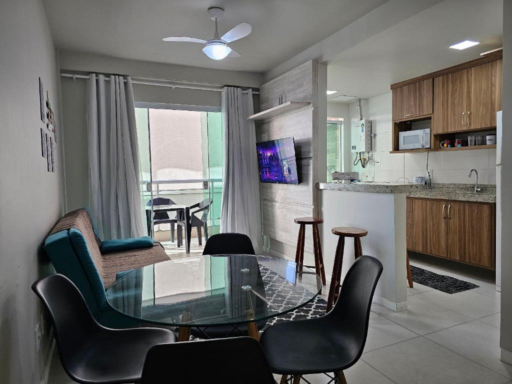 a kitchen and living room with a glass table and chairs at AP encantador na Praia do Forte! Porto Azul (107) in Cabo Frio
