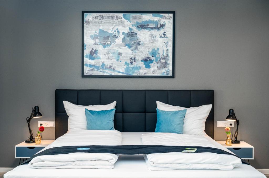 - une chambre dotée d'un grand lit avec des oreillers bleus et blancs dans l'établissement Hotel Das Q Spaichingen, à Spaichingen