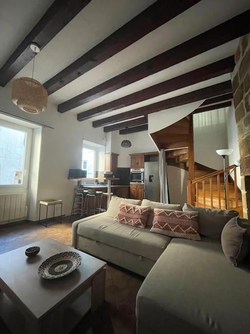 ein Wohnzimmer mit einem Sofa und einem Tisch in der Unterkunft Maison Hyper Centre Brive in Brive-la-Gaillarde
