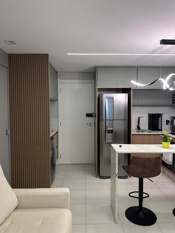 a kitchen and living room with a table and a couch at Studio Chácara Sto Antonio in Sao Paulo