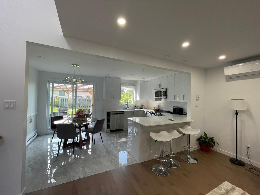 a kitchen and living room with a table and chairs at Beautiful Renovated House Laval in Laval