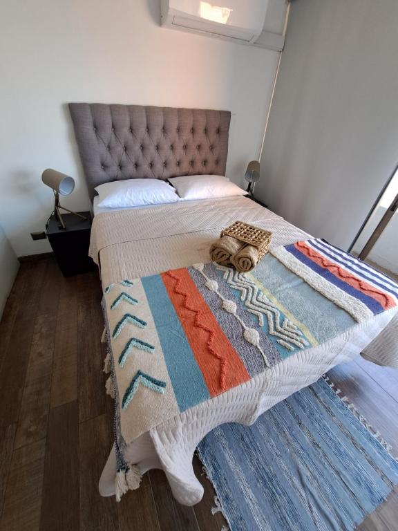un letto in una stanza con una coperta sopra di Rocky House - Hostal Boutique Providencia a Santiago