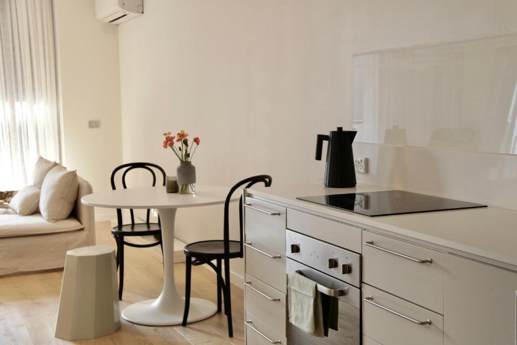 a white kitchen with a table and a counter top at Collingwood Studio Hideaway in Melbourne
