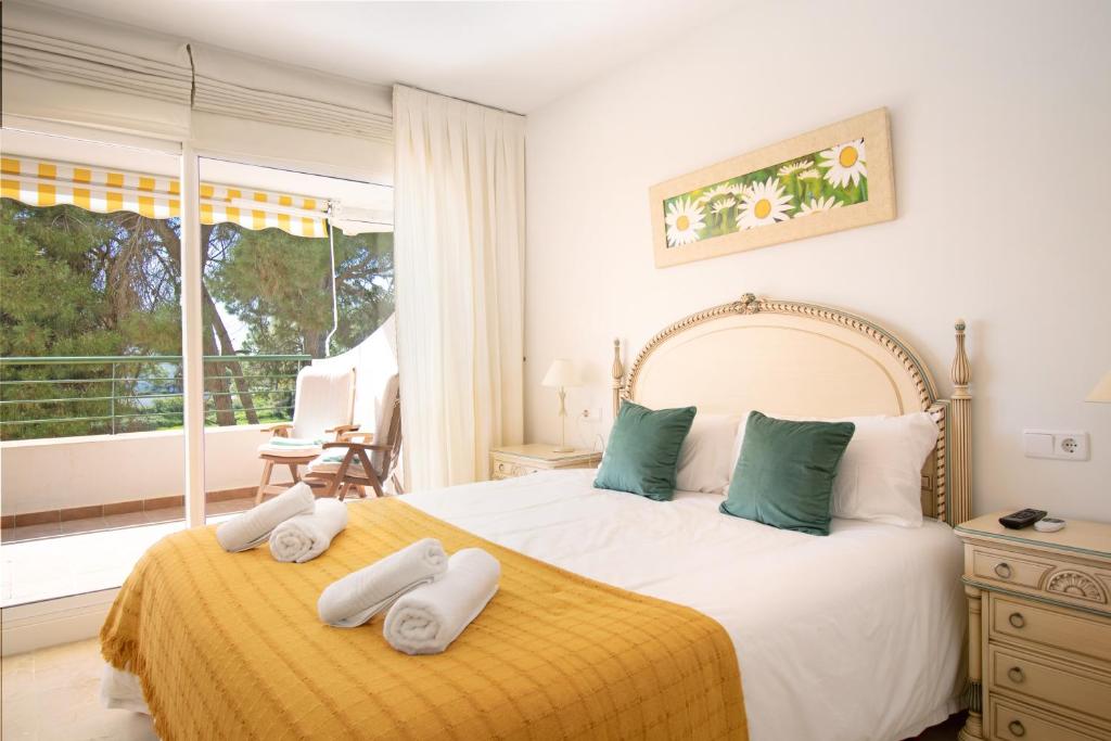 a bedroom with a large bed with towels on it at Apartamento con espectaculares vistas al Golf en Marbella - Xallas 2 3 in Marbella