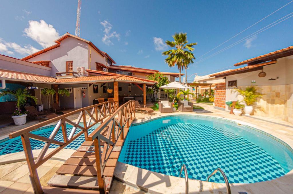 a swimming pool in front of a house at Pousada Sete Mares in Barra de São Miguel