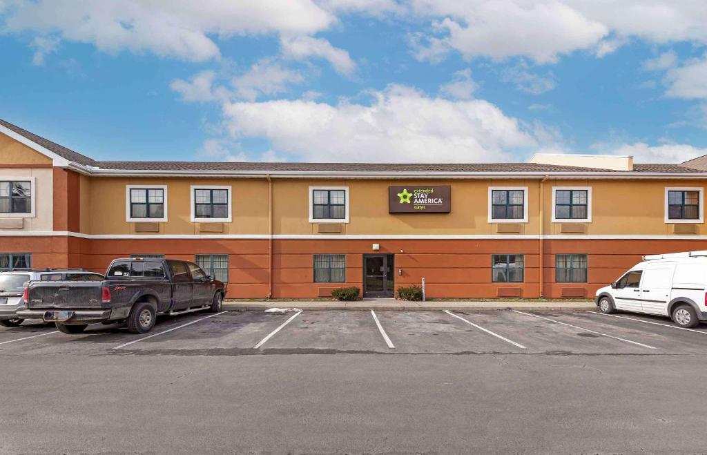 a hotel with cars parked in a parking lot at Extended Stay America Suites - Rochester - Greece in Greece