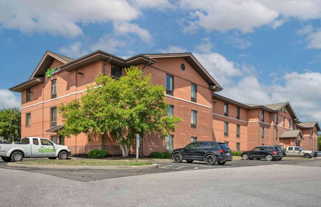 un gran edificio de ladrillo con coches aparcados en un aparcamiento en Extended Stay America Suites - Pittsburgh - Airport en Imperial