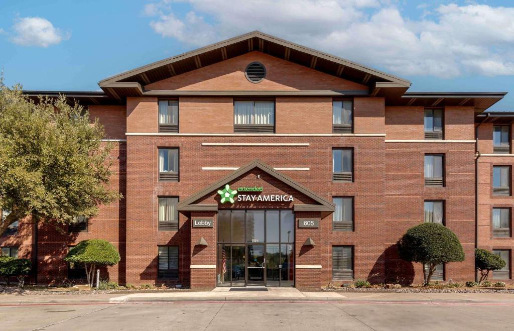 a large red brick building with a supermarket sign on it at Extended Stay America Select Suites - Dallas - Las Colinas - Meadow Creek Dr in Irving