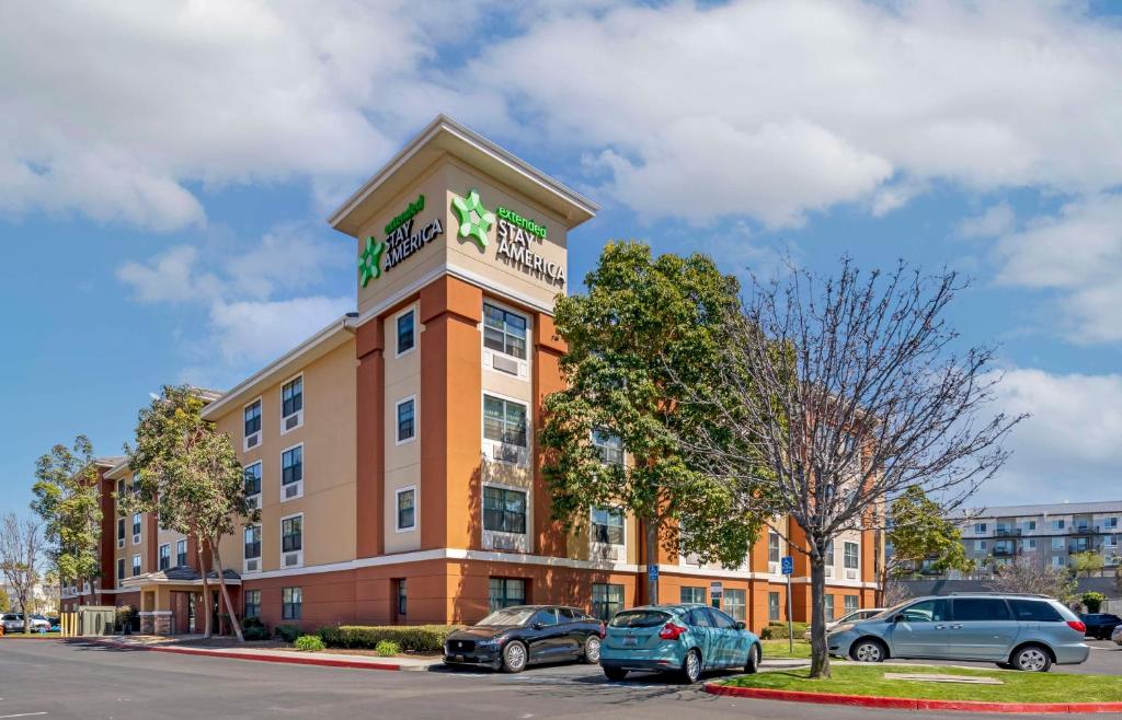 een gebouw met auto's geparkeerd op een parkeerplaats bij Extended Stay America Suites - Orange County - Katella Ave in Orange