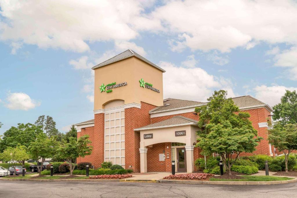 Un edificio con un cartel al costado. en Extended Stay America Select Suites - Richmond - West End - I-64, en Short Pump