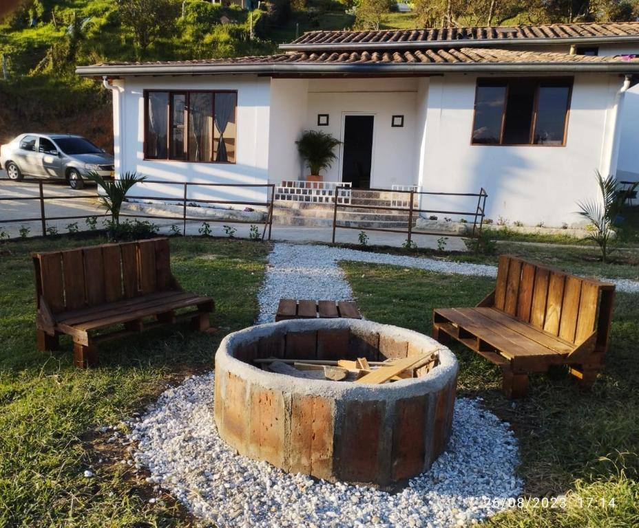 two benches and a fire pit in front of a house at El paso Gh #1 in Guarne