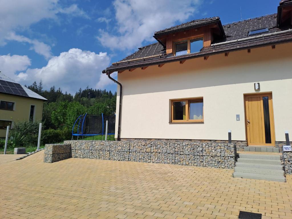 Apartmány Horní Bečva في هورني بيسافا: منزل أبيض بحائط حجري