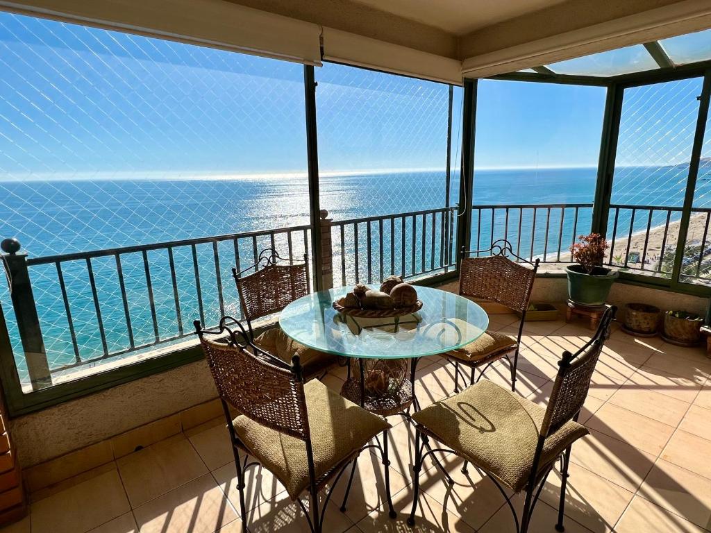 a balcony with a table and chairs and the ocean at VISTAMAR CORACEROS VIÑA DEL MAR in Viña del Mar