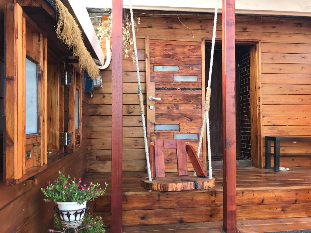 a wooden cabin with a chair on the porch at A-HOME in Jiufen